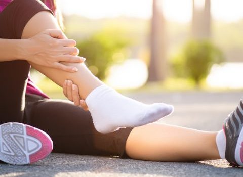 Ankle sprained. Young woman suffering from an ankle injury while