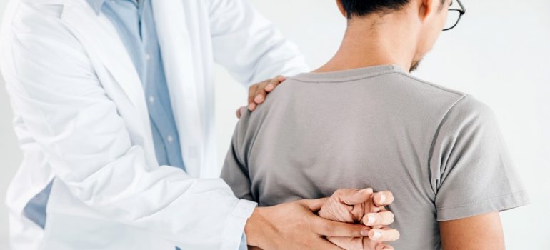 Physiotherapist doing healing treatment on man's back.Back pain
