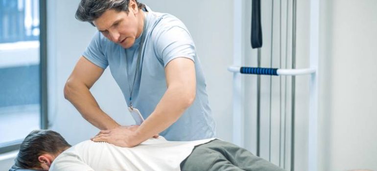 Physiotherapist assisting a patient with spinal physiotherapy treatment.