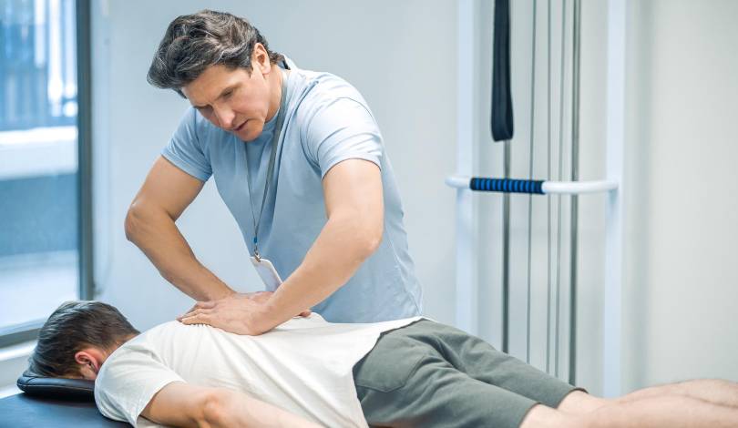 Physiotherapist assisting a patient with spinal physiotherapy treatment.