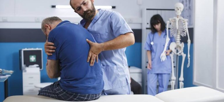 Physiotherapist assisting patient with shoulder physiotherapy exercises.