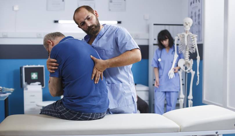 Physiotherapist assisting patient with shoulder physiotherapy exercises.