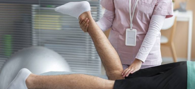 Physiotherapist guiding a patient through knee pain physiotherapy treatment.