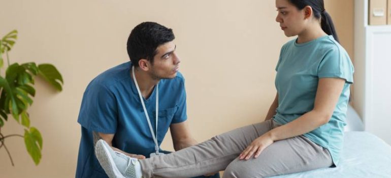Physiotherapist assisting patient in knee strengthening exercises