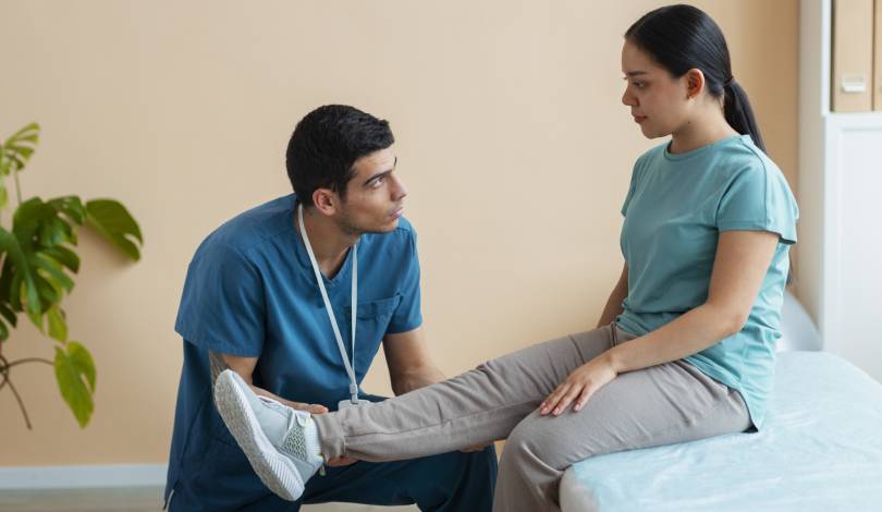Physiotherapist assisting patient in knee strengthening exercises