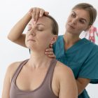 physiotherapist-helping-patient-her-clinic