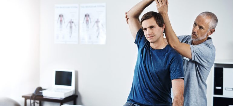 physiotherapist-guiding-passive-range-of-motion-exercises-for-a-patient-with-a-fractured-humerus