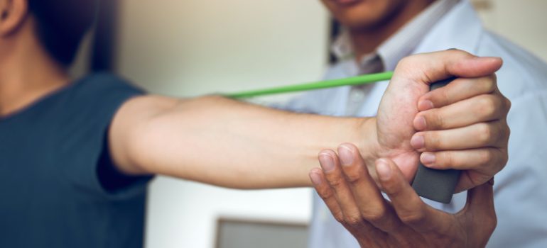 physiotherapist-applying-therapeutic-taping-for-physiotherapy-for-tennis-elbow