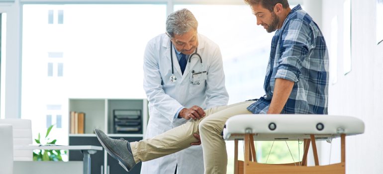 physiotherapist-assisting-a-patient-with-safe-controlled-strengthening-exercise-for-the-knee