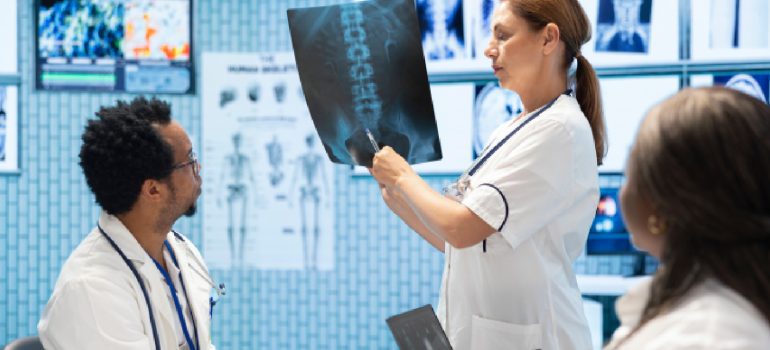 medical-team-including-a-doctor-and-physiotherapist-reviewing-a-patients-spinal-x-ray-together