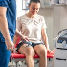 patient-working-with-a-physiotherapist-on-a-specialized-strength-machine-after-knee-surgery