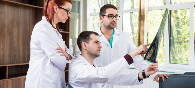 a-team-of-specialists-doctor-physio-and-chiropractor-reviewing-a-patients-digital-spine-analysis