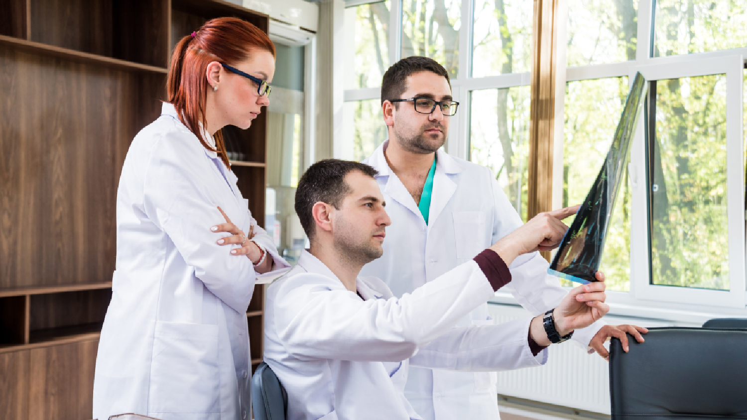 a-team-of-specialists-doctor-physio-and-chiropractor-reviewing-a-patients-digital-spine-analysis